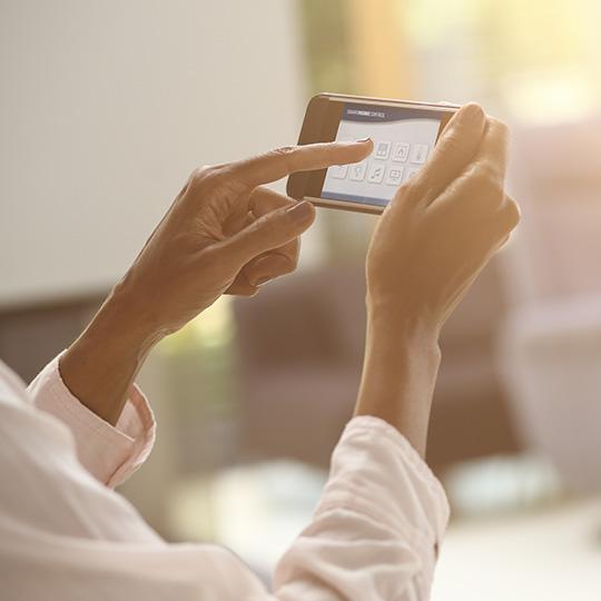 Utveckla Internet of Things close up of hands using a smartphone