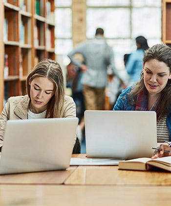 people working at laptops in a library